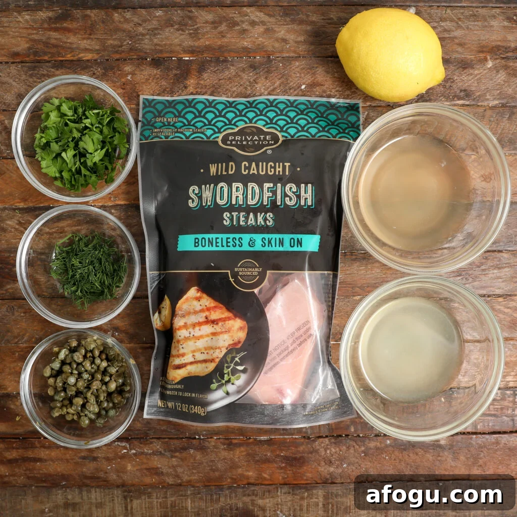 Ingredients for Swordfish Piccata: a package of wild caught swordfish steaks, a lemon, bowls of chopped parsley, dill, capers, and bowls with liquids, all arranged on a wooden surface.