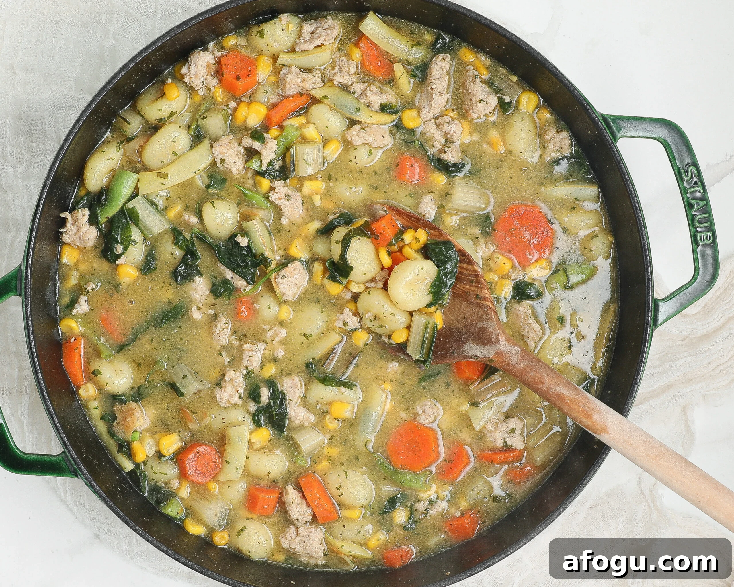 Creamy chicken gnocchi with tender chicken, potato gnocchi, carrots, corn, kale, and herbs in a creamy broth.