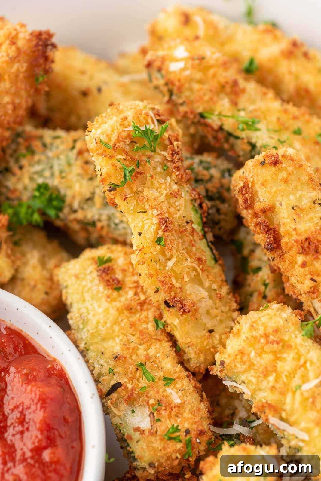 Close up of breaded zucchini fries on a platter.