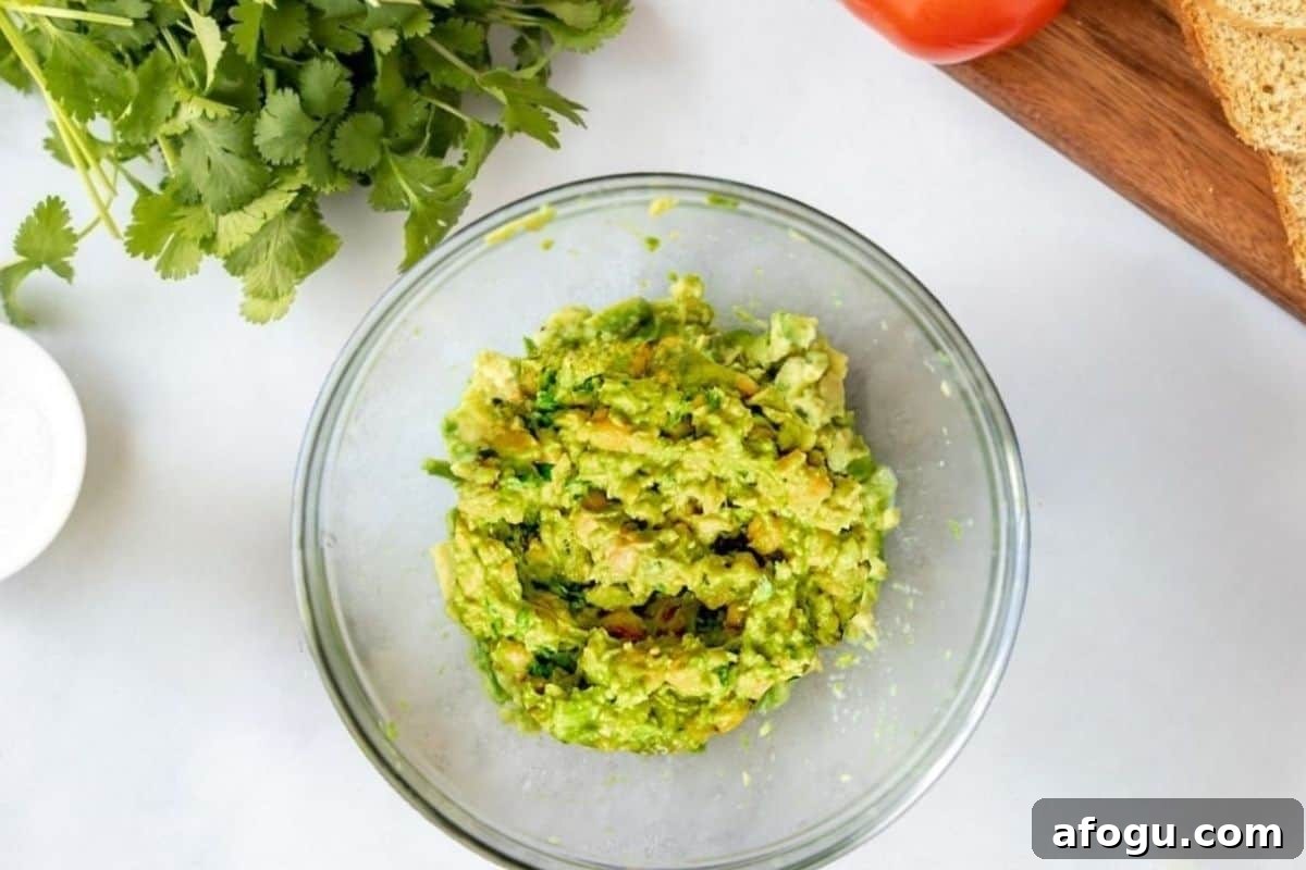 Bowl with smashed chickpeas mashed into avocado.
