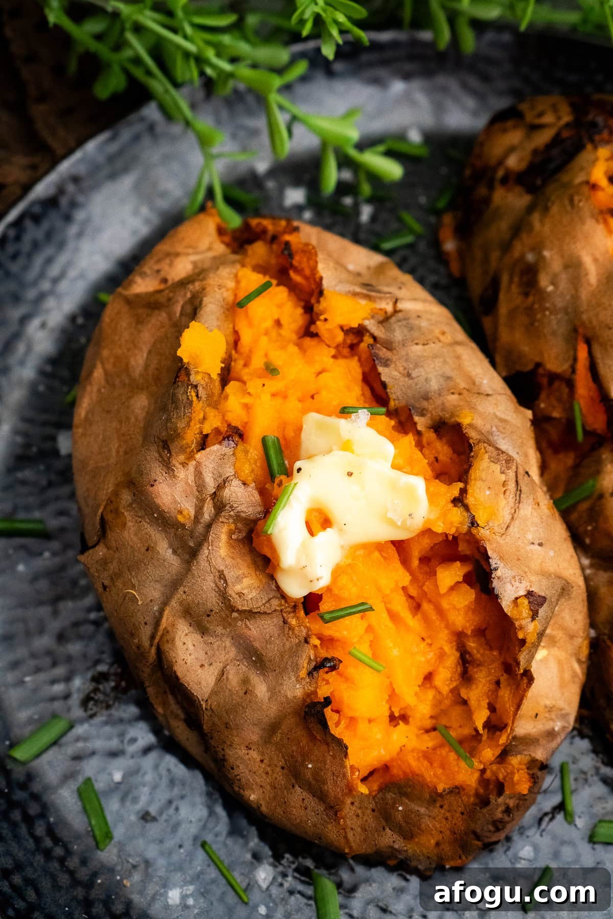 Jacket Sweet Potato cut open with butter on top and chopped chives