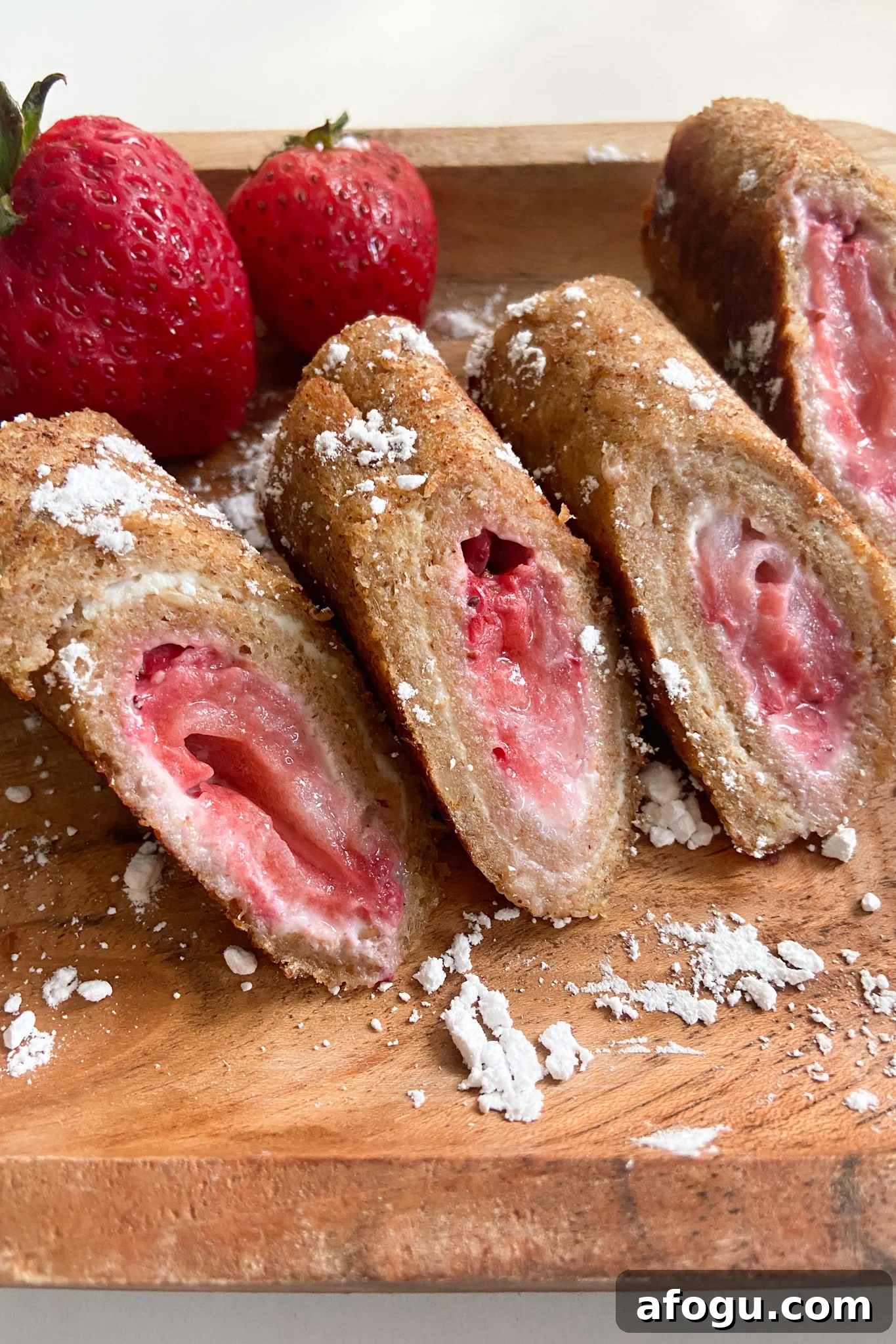 Strawberry cheesecake rollups dusted with powdered sugar