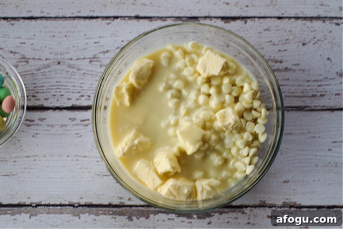 Milk chocolate chips, white chocolate chips, sweetened condensed milk, and butter in a large glass microwave-safe bowl.