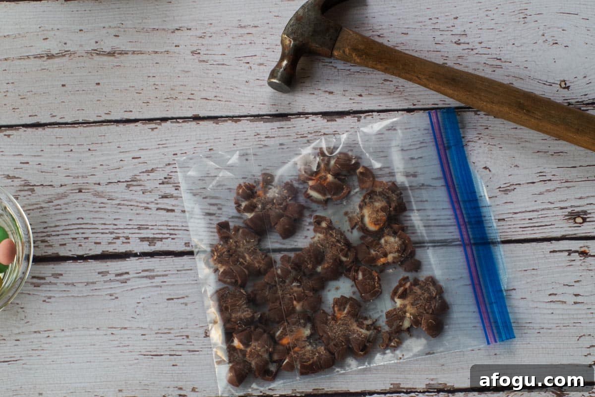 Mini eggs crushed in a Ziploc bag beside a hammer.