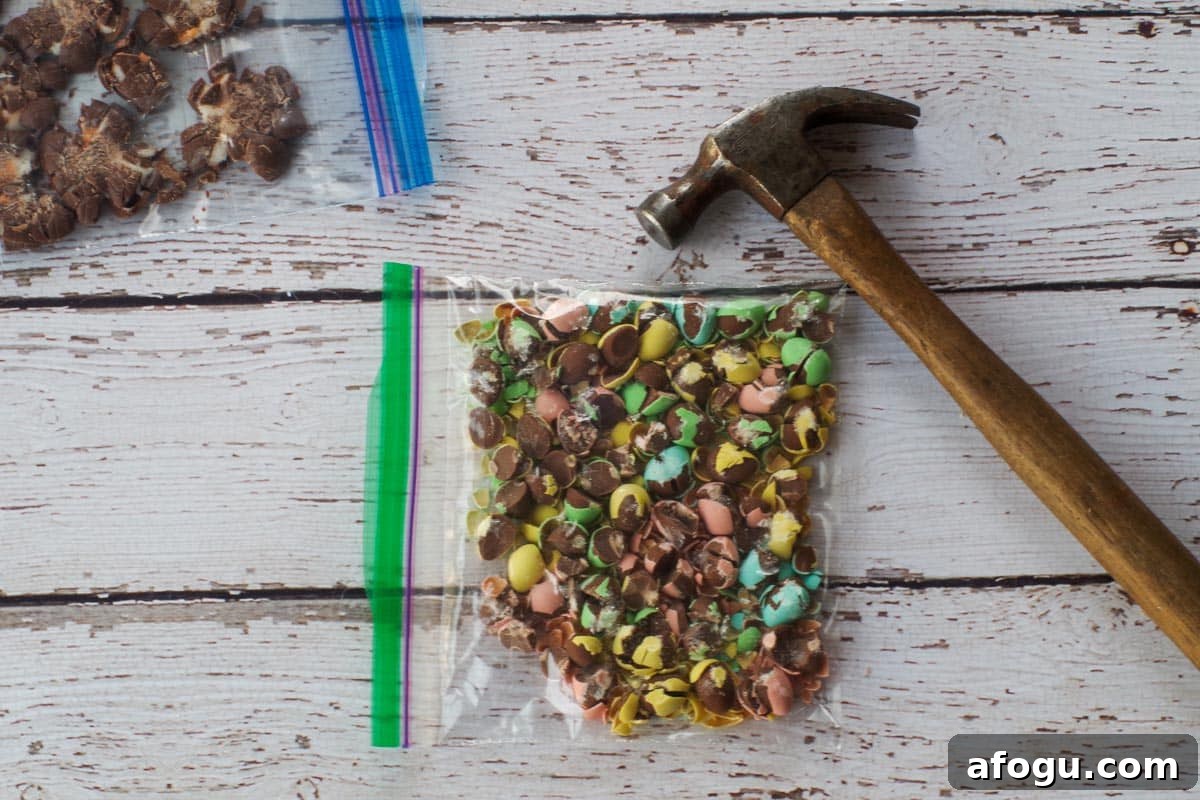 Crushed mini eggs in a Ziploc bag with a hammer beside it.