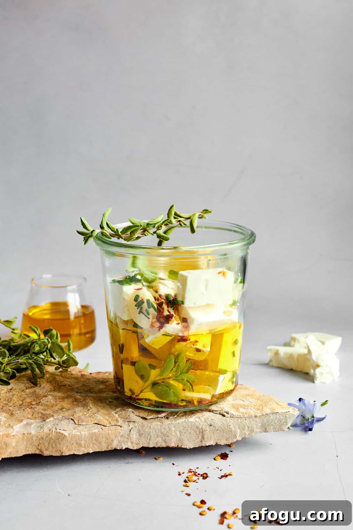 Feta cubes being soaked in an olive oil marinade.