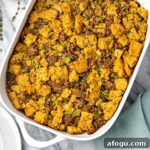 Cornbread stuffing in a white casserole dish sitting on a marble counter.