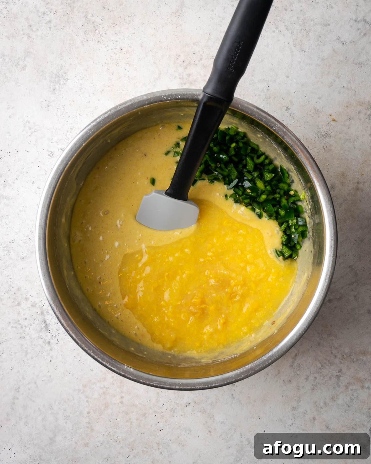 Creamed corn and poblano peppers added to the partially mixed corn casserole batter.