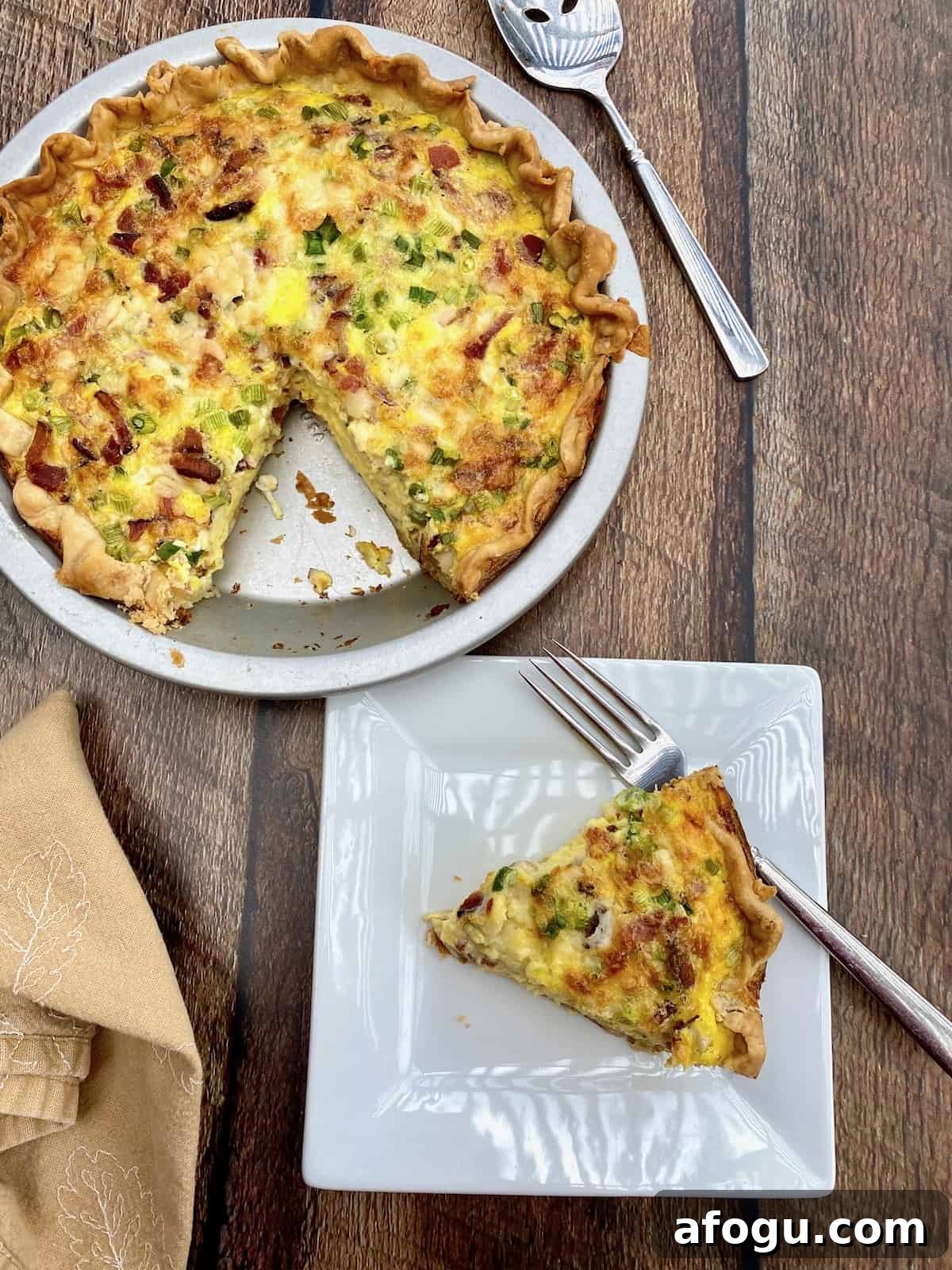 A wedge of cougar gold cheese on a small plate next to dish of quiche.