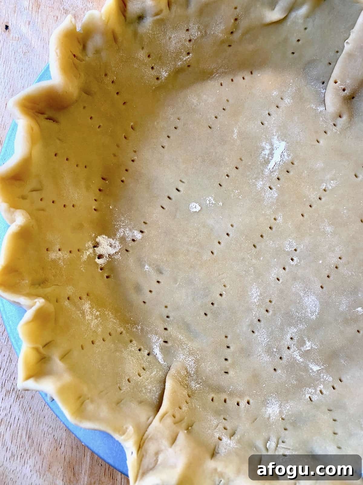 Quiche crust, unbaked with small holes from a fork.